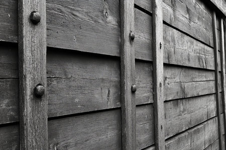 Weathered Wood Paneling with Vertical Timbers and Rivets, Showcasing Rustic Craftsmanshipの素材