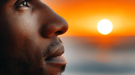 Serene Man Deep in Thought as He Watches a Stunning Sunrise Reflecting on Calm Watersの素材