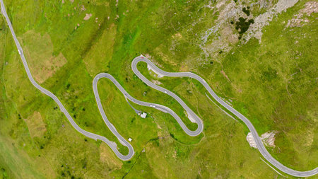 Aerial View of a Winding Mountain Road Through Green Fields Scenic Landscape, Travelの写真素材