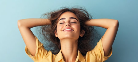 Young Woman with Closed Eyes Smiling Peacefully in Studio, Embracing Positive Emotions and Wellbeingの素材