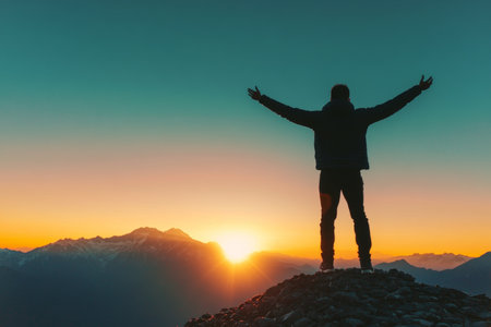 A Majestic Sunrise Silhouette of a Triumphant Hiker Celebrating on a Mountain Summit at Dawnの素材