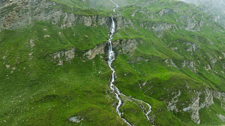 Majestic Mountain Waterfall Scenery, Lush Greenery, and Stunning Natural Beauty Above the Cloudsの写真素材