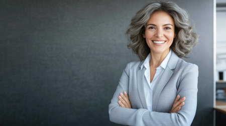 Confident Latin Hispanic Senior Female with Gray Hair Standing, Smiling Coach with Arms Crossedの素材
