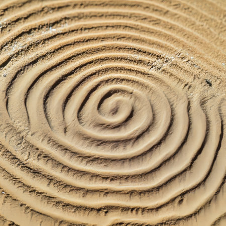 Mesmerizing Abstract Swirl in Golden Sand Dunes, Captivating Spiral Pattern of Textured Sand Surfaceの素材