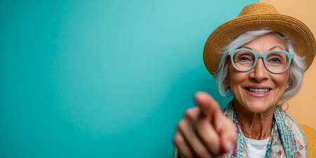 Cheerful elderly woman with a friendly smile, pointing forward and inviting others to join her joy.の素材