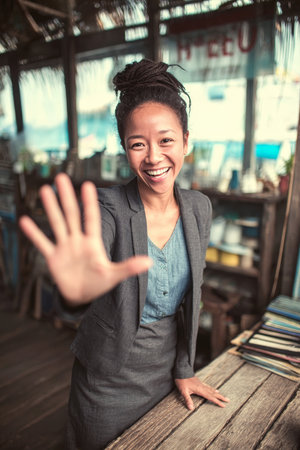 Smiling young African American salesperson greets clients in a bright modern office workspaceの素材