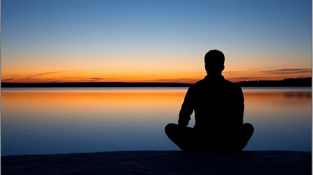 Serenity Embrace Silhouette of a Meditative Figure at Peaceful Lakeside During Tranquil Sunriseの素材