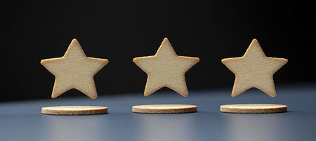 Three Elegant Star Shaped Cookies Rising Above Tiny Circular Pedestals Against a Dark Backgroundの素材
