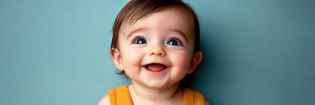 Adorable Infant with a Charming Smile Against a Soft Teal Background, Radiating Joy and Innocenceの素材