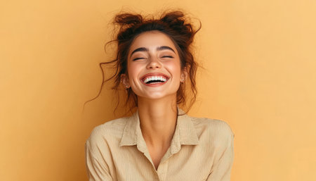 Joyful Brunette Woman Laughing with Closed Eyes and Perfect Teeth over a Bright Yellow Backgroundの素材