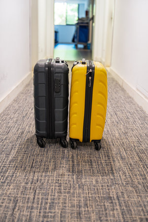 Suitcases Ready for Adventure Awaiting Departure in a Hotel Hallway with Carpet Floorの写真素材