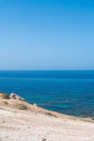 Coastal Serenity Azure Waters and Rocky Shores Under Clear Skies in Picturesque Cyprus, Europe
