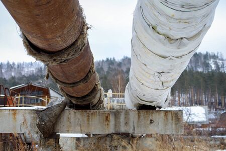 old pipeline on the edge of the city with torn insulationの写真素材