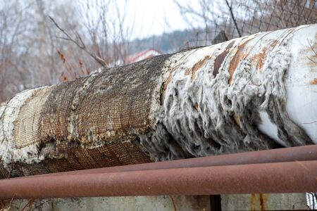 old pipeline on the edge of the city with torn insulationの写真素材
