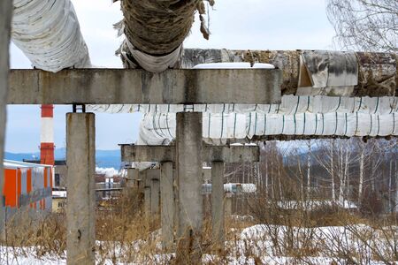 old pipeline on the edge of the city with torn insulationの写真素材