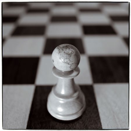 chess piece - pawn with drawing mainlands on chess-boardの写真素材