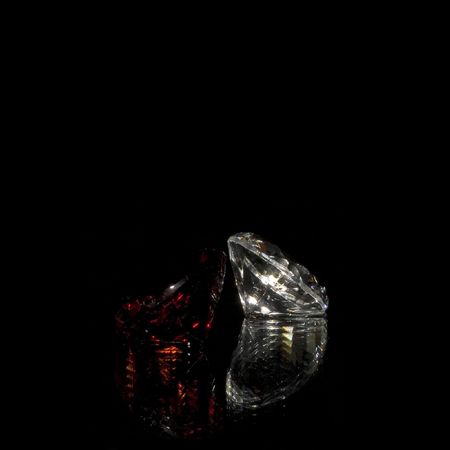 Red and white diamonds with reflection on blackの写真素材