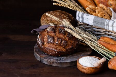 Concept of homemade bread, natural farm products, domestic production. Healthy and tasty organic food. Close up, dark black background. Copy space for textの写真素材
