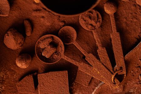 Delicious homemade chocolate preparation process. All kitchen tableware covered with cocoa powder. Intense brown color, aromatherapy. Dark and moody, macro, flat lay, top viewの写真素材