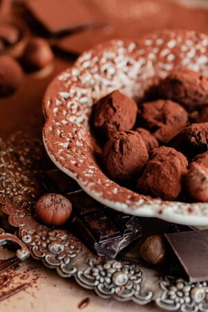 Homemade delicious dark chocolate truffles. Served in white vintage plate, sprinkled with cocoa powder. Delicious elegant dessert for sweet-tooth. Romantic atmosphere. Close up, macroの写真素材