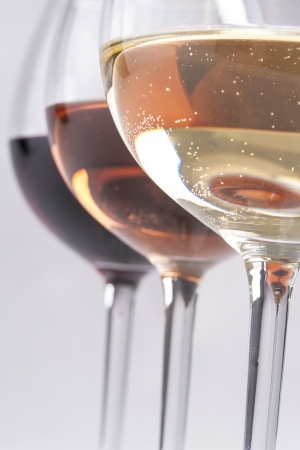 Three wine glasses with different wines - red, rose and white on a solid backgroundの写真素材