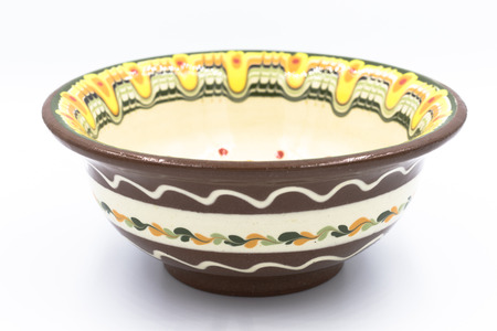 Hand made and hand painted soup bowl viewed from the side with  green,orange and yellow bright colorsの写真素材
