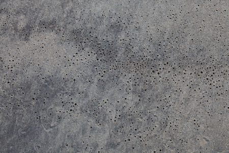 Flat sand on the beach with small black holes, for background