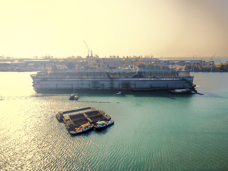 aerial view shipyard have crane machine and container ship in green sea .のeditorial素材
