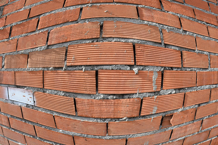 A brick wall has one piece defective and different