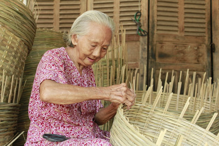 In order to make a basket, the sawmill worker first turned into 2m long sections. Next is the bamboo segment was cut in step above into many small plus. These rods are put into the machine to split inのeditorial素材