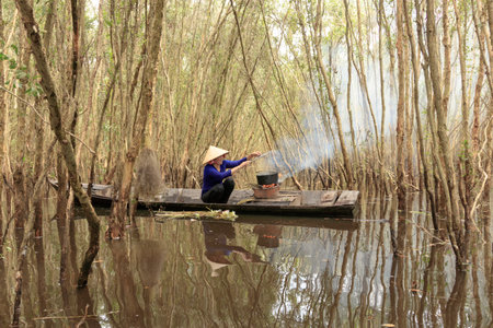 The author took a photo shoot on Sunday morning October 11, 2020. Location in Long An province, Vietnam. Content: the couple is cooking in the Melaleuca forest.のeditorial素材