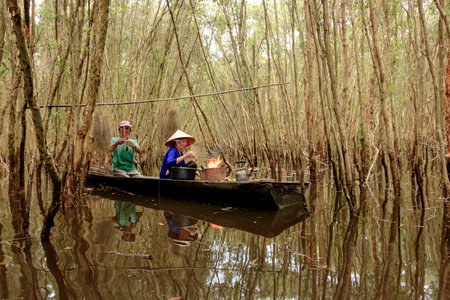 The author took a photo shoot on Sunday morning October 11, 2020. Location in Long An province, Vietnam. Content: the couple is cooking in the Melaleuca forest.のeditorial素材