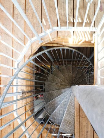 metal spiral staircase and wooden floorの写真素材