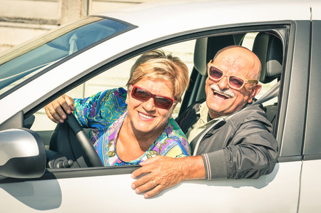Happy senior couple ready for driving a car on a journey trip - Concept of joyful active elderly lifestyle with man and woman enjoying their best yearsの写真素材