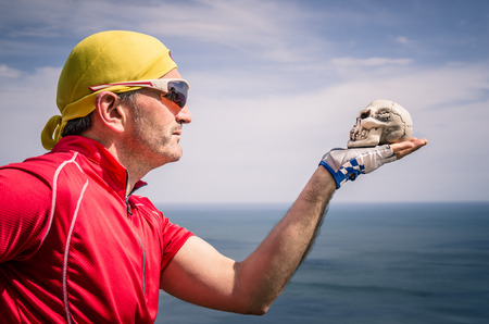 Cyclist with bandana Headband looking at a Skullの写真素材