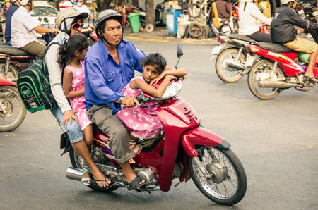 HO CHI MINH CITY, VIETNAM - FEBRUARY 6, 2013: full family driving a scooter in the city traffic. There are approximately 340,000 cars and 3,5 million motorcycles in the city.のeditorial素材