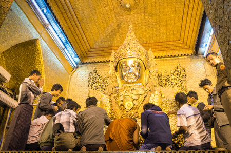 MANDALAY, MYANMAR - 10 FEBRUARY, 2014: daily morning ritual at golden Mahamuni Buddha image in Mahamuni pagoda; the temple is a major pilgrimage site in Burma and the statue is original from Arakanのeditorial素材