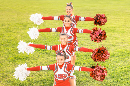 Group of cheerleaders in action with female coach - Concept of unity and team sport - Training at...