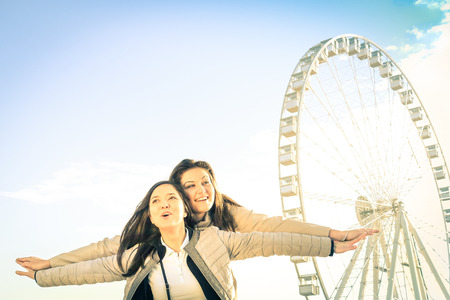 Best female friends enjoying time together outdoors at luna park  - Concept of friendship and happiness with two girlfriends having fun - Happy people at ferrisの写真素材