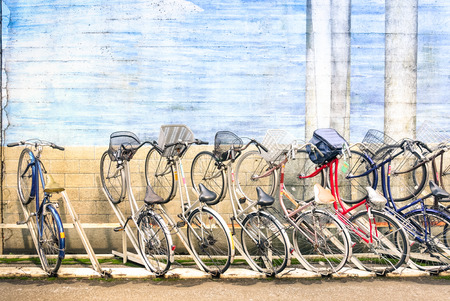Multicolored vintage bicycles in metal rack in Tokyo city の写真素材