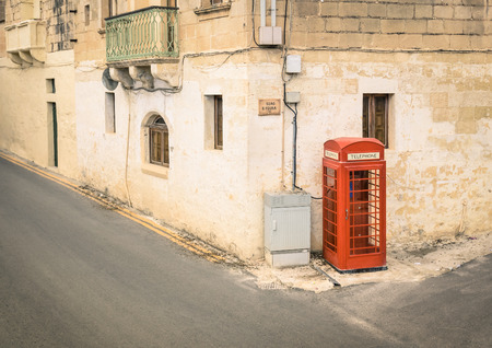 Red telephone cabin in the medieval old town of Victoria in Gozo - Mediterranean archipelago of...