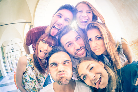 Best friends taking selfie outdoors with back lighting - Happy friendship concept with young people...