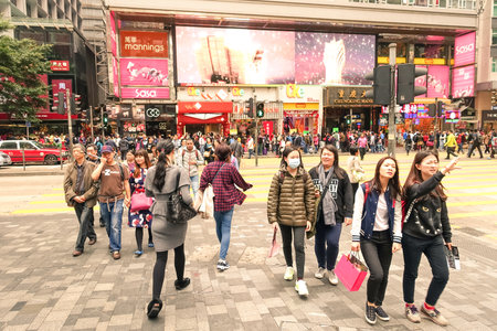 HONG KONG - 22 FEBRUARY 2015: crowd of multiracial people crossing the road on Nathan Street near Tsim Sha Tsui in city heart of Hong Kong; special administrative region of People's Republic of Chinaのeditorial素材