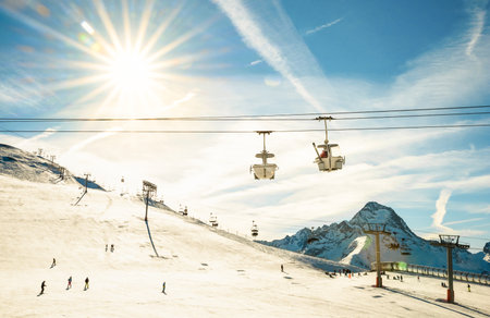 Glacier ski resort and chair lift in french alps - Winter sports vacation and travel concept - Snowboard season opening and people having fun on mountain - Warm afternoon color toneのeditorial素材