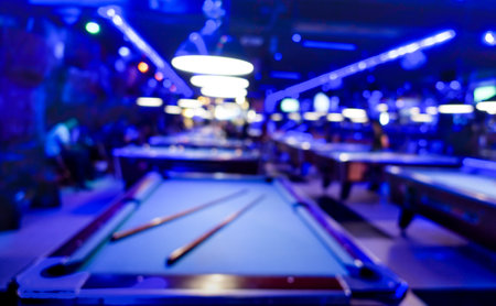 Defocused background of billiard playroom - Blurred composition of pool game saloon with dominant blue color tones and incandescent neon light - Fun and entertainment concept with blurry dark backdropの写真素材