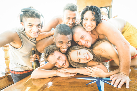 Group of best friends guys and girls taking selfie at sailing boat - Happy youth friendship concept...