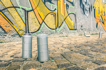 Detail of aerosol spray can at colorful graffiti on wall - Modern street art concept with urban painting perform and murales live preparation - Bright vintage retro filterの写真素材