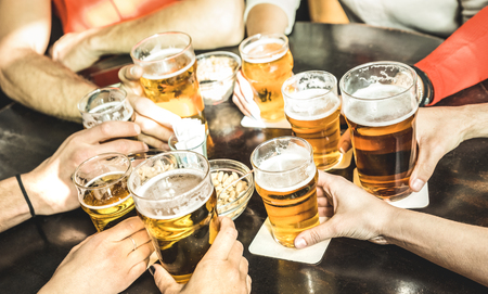 Friends hands drinking beer at brewery pub restaurant - Friendship concept with young people enjoying time together and having genuine fun at cool vintage brew bar - Focus on middle right small glassの写真素材