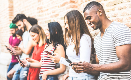 Multiracial friends group using smartphone at university college break - Millenial people addicted...