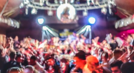 Blurred people dancing at music concert event - Abstract defocused background of disco club after party at live stage festival - Nightlife entertainment concept - Bright spotlight filterの写真素材